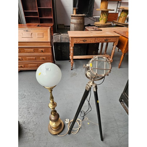 121 - A brass standard lamp with globe shade together with a floodlight on a tripod base