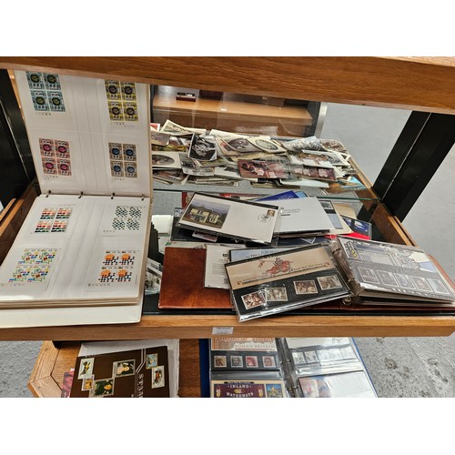 269 - A collection of mint British stamps in albums and collectors sets - displayed over three shelves