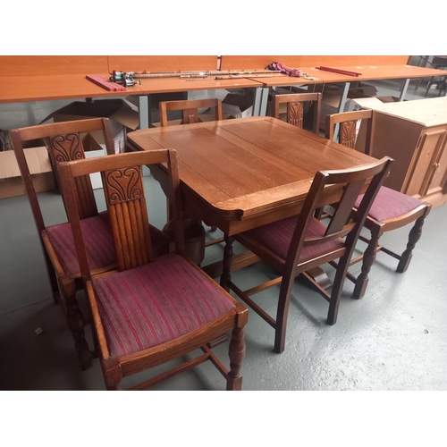 412 - An oak draw leaf dining table and six chairs