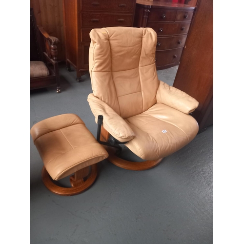 419 - A leatherette swivel armchair with matching footstool