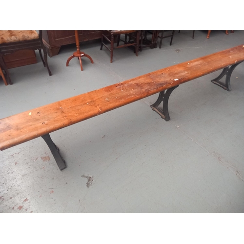 425 - A school bench on cast iron legs 

Length 288cm