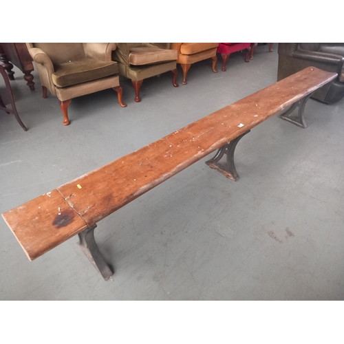 426 - A school bench on cast iron legs

Length 288cm