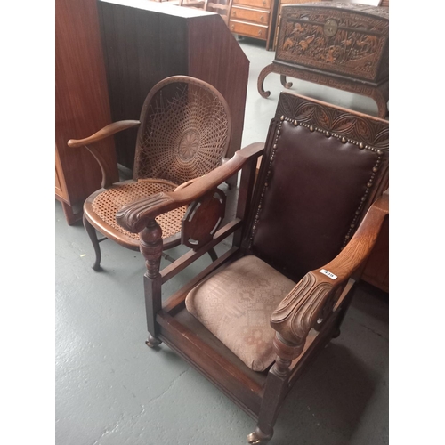 439 - An oak steamer chair together with a cane seated armchair with damage to cane