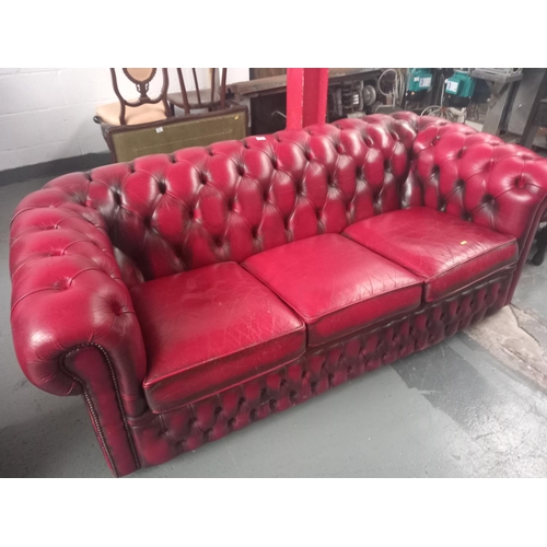 479 - A red leather Chesterfield three seater sofa