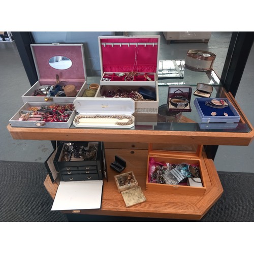 516 - A quantity of costume jewellery and watches - displayed over two shelves