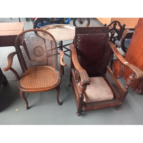 639 - An oak steamer chair together with a cane seated armchair with damage to cane