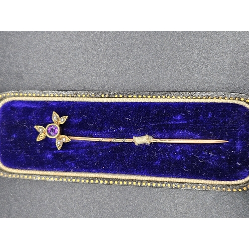 566 - A 15k gold tie pin with purple stone and seed pearls (one pearl is missing)