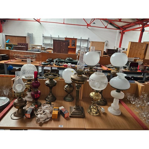 319 - A collection of glass and brass oil lamps