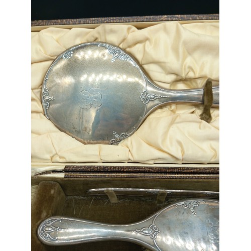 513 - A boxed hallmarked silver dressing table set - mirror and brushes