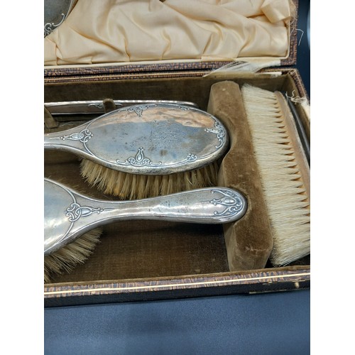 513 - A boxed hallmarked silver dressing table set - mirror and brushes