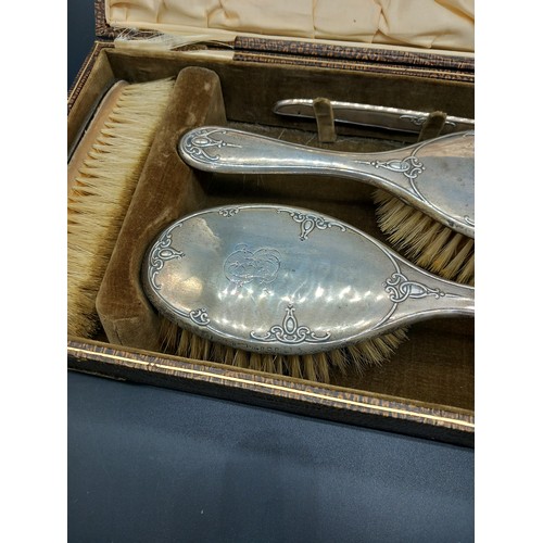 513 - A boxed hallmarked silver dressing table set - mirror and brushes