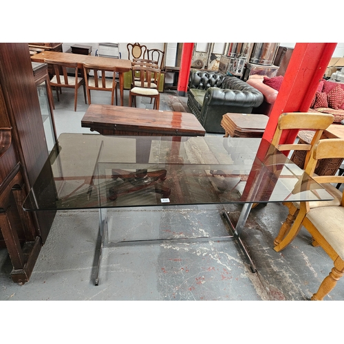 432 - A smoked glass topped chrome framed dining table believed to be Merrow Associates 

Measures: Width ... 