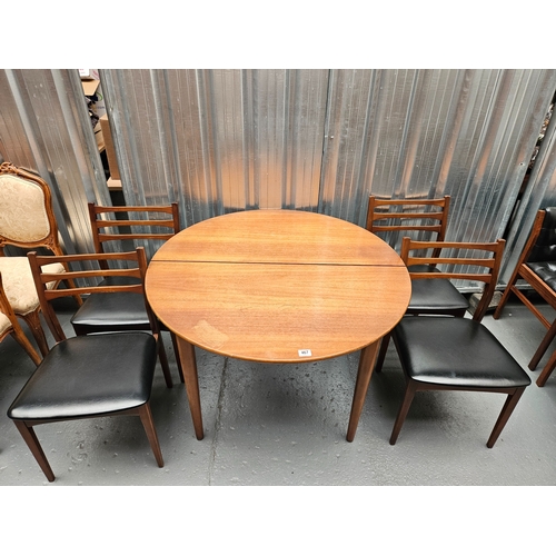 467 - A circular teak extending dining table and 4 chairs