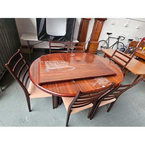 480 - A mid century rosewood extending dining table with 2 extra leaves and 6 chairs (designer marked on b... 