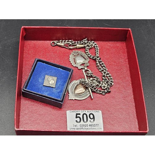 509 - Two silver watch fobs, a silver watch chain and a silver Ford 25 year lapel badge - silver weight 44... 