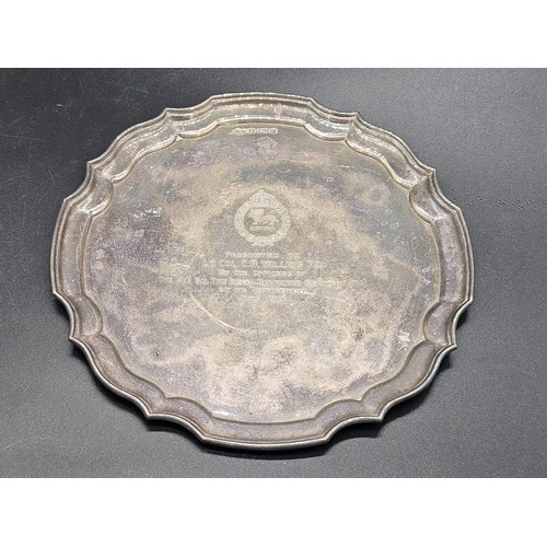 503 - A hallmarked silver card tray with scalloped border of military interest - inscription reads 