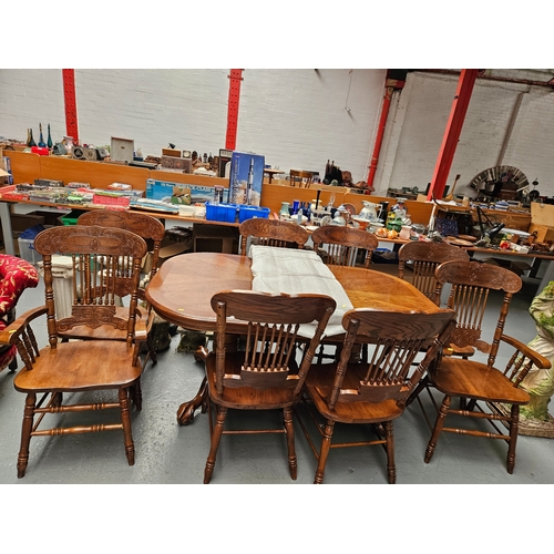 388 - An oak extending dining table with one extra leaf and 8 chairs to include 2 carvers