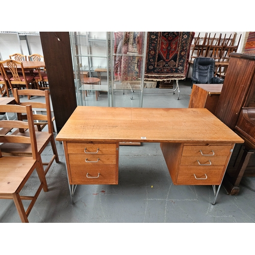 401 - A teak twin pedestal desk on metal legs 

Measurements: Depth 68cm, Height 75cm, Width 140cm