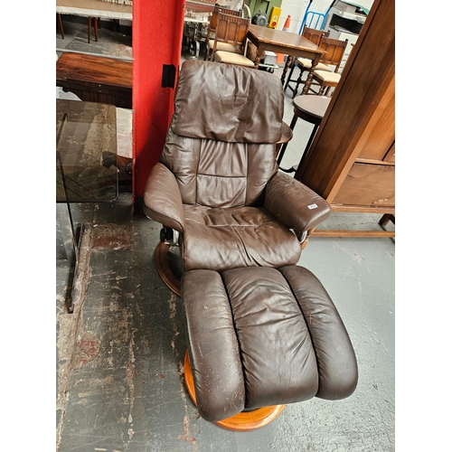 403 - A leather Stressless swivel reclining armchair with leather footstool