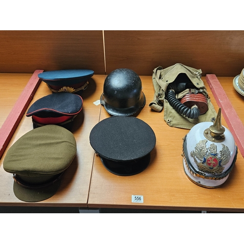 556 - Three military caps, a St Johns Ambulance cap, a reproduction Pickelhaube Prussian helmet, a German ... 