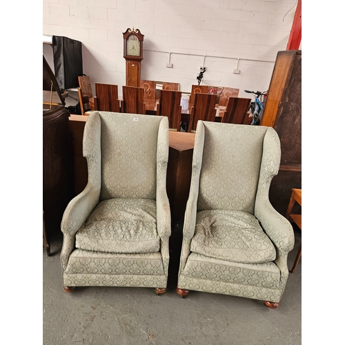 638 - A pair of wingback upholstered armchairs on castors