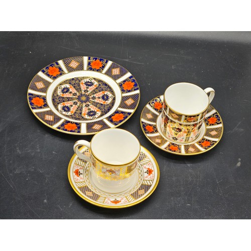 824 - A collection of Royal Crown Derby pieces - two coffee cups and saucers, a cat paperweight with stopp... 