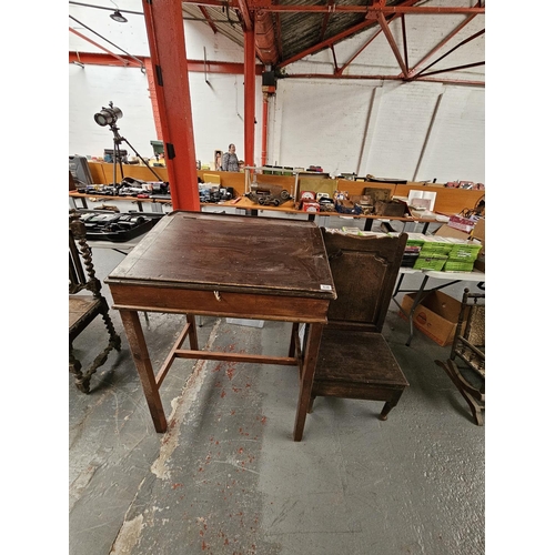 630 - An oak lambing chair together with a clerks/school lift top desk