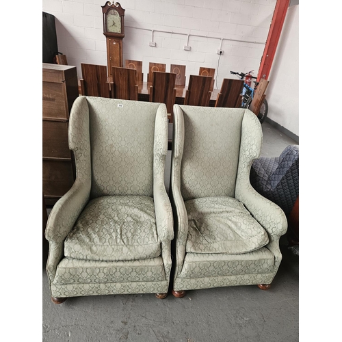 648 - A pair of wingback upholstered armchairs on castors