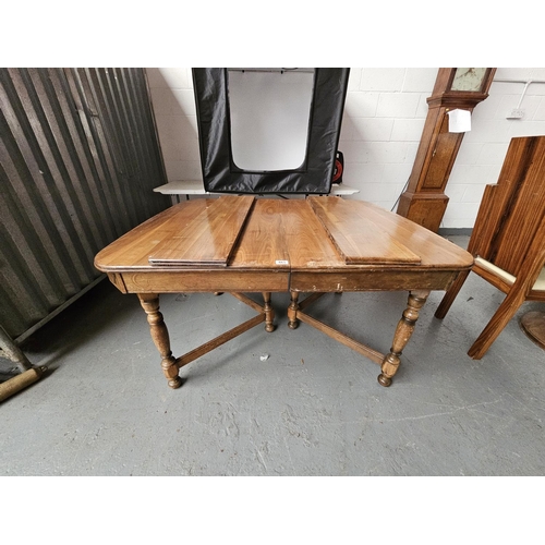 665 - An oak extending dining table with 2 leaves (needs attention)