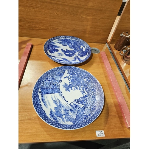 379 - Two large oriental blue and white plates with decoration to the reverse - approximate diameter is 15... 