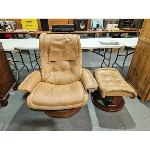 404 - A tan leatherette swivel reclining armchair with a matching footstool