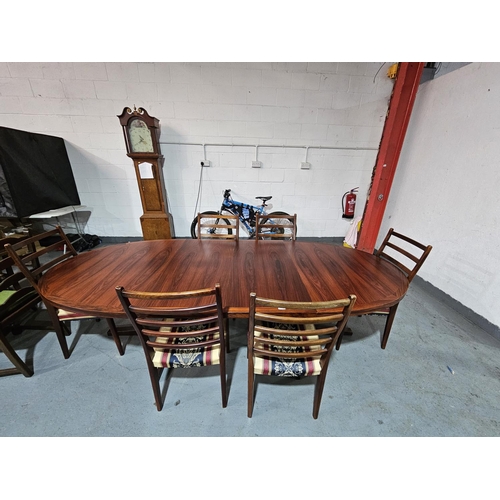 442 - An oval rosewood extending dining table with two extra leaves and six chairs