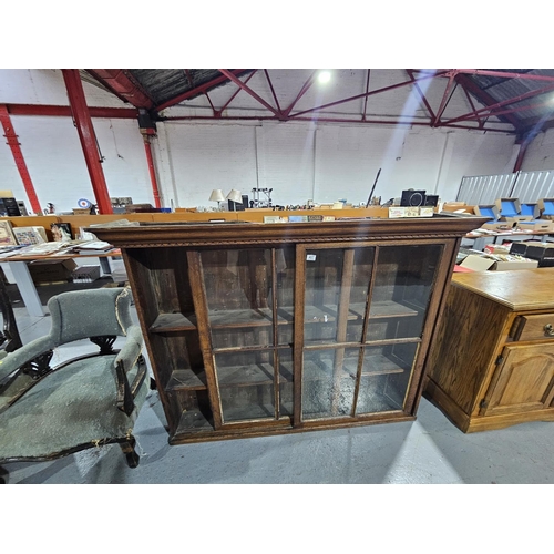 407 - An oak bookcase with two gazed sliding doors
H 122cm
W 157cm
D 28cm