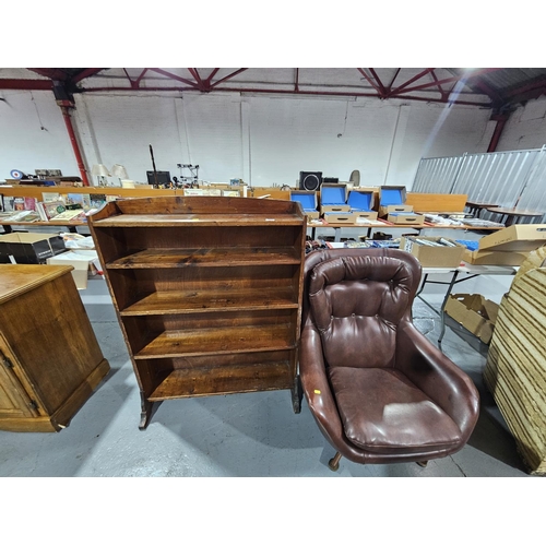 409 - A leatherette swivel armchair together with an oak bookcase