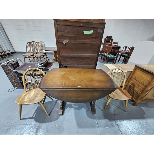 412 - An Ercol drop leaf dining table and two Ercol Windsor chairs