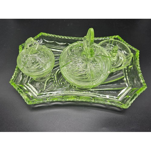 501 - A uranium glass dressing table set (chip to one lid) together with a uranium glass vase