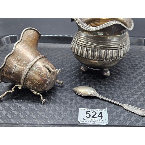 524 - Two hallmarked silver cream jugs- hallmarks for London and Birmingham and a silver teaspoon - weight... 