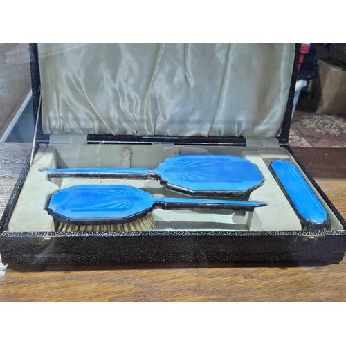 513 - A boxed dressing table set of mirror and brushes - enamel on silver plate