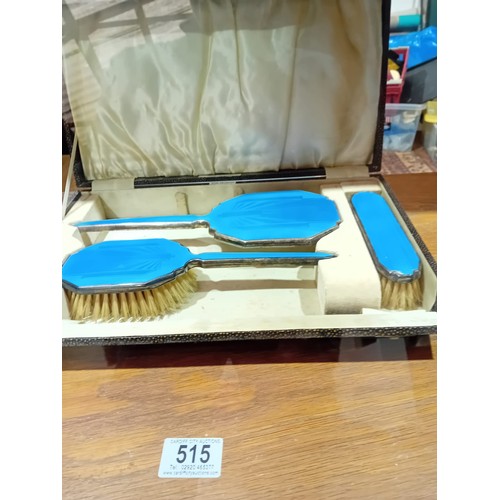 515 - A boxed dressing table set of mirror and brushes - enamel on silver plate