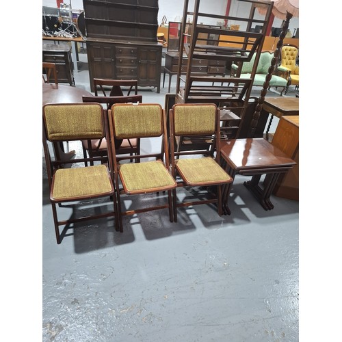 436 - Three folding chairs together with a mahogany nest of tables