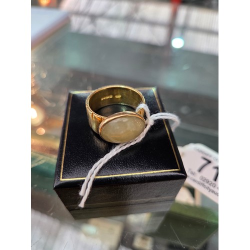 717 - An 18 carat gold dress ring with green stone - weight including stone 13 grams