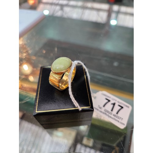 717 - An 18 carat gold dress ring with green stone - weight including stone 13 grams