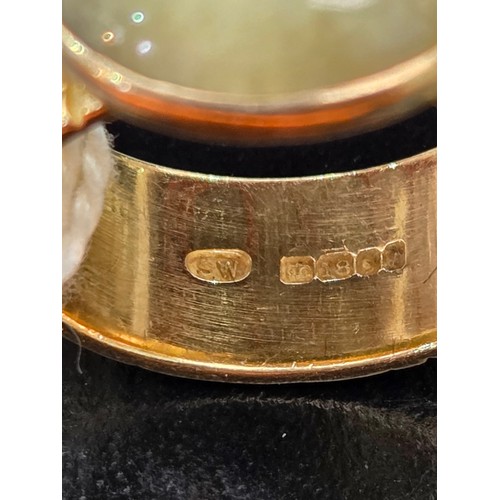 717 - An 18 carat gold dress ring with green stone - weight including stone 13 grams