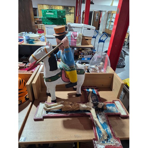 633 - A paper mache monk and tiger together with a wooden figure on crucifix and a figure on horseback wit... 