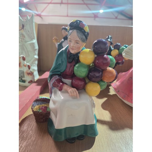 517 - Eight large Royal Doulton figurines - The Old Balloon Seller, The Balloon Seller, Biddy Pennyfarthin... 