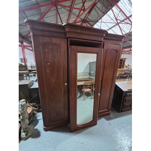 434 - A mahogany three sectioned wardrobe with mirrored centre door measurements: Height 214cm, width 193c... 