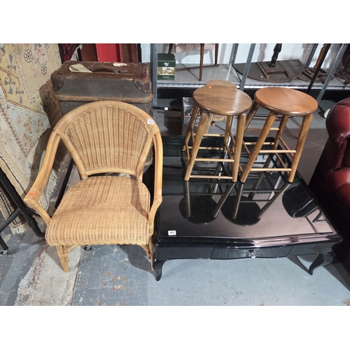 462 - A black laquered glass top coffee table, stools, travel trunk and a wicker chair