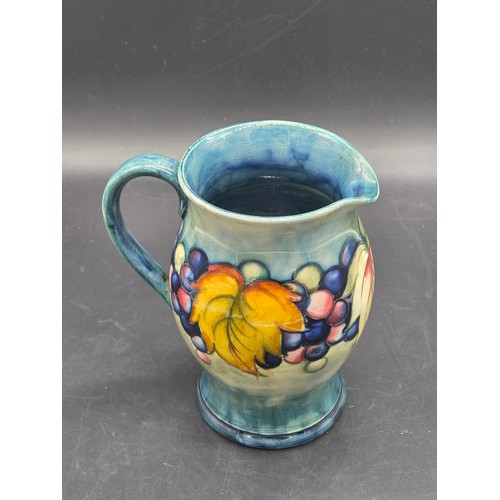 502 - A William Moorcroft jug in the leaf and berry pattern - impressed Moorcroft mark and blue signature ... 