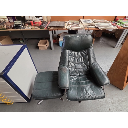 504 - A green leather swivel armchair with matching footstool