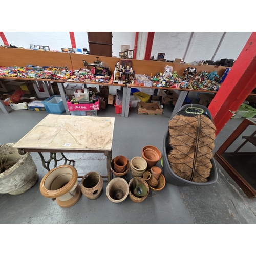 509 - A cast iron base table together with ceramic and terracotta plant pots, etc